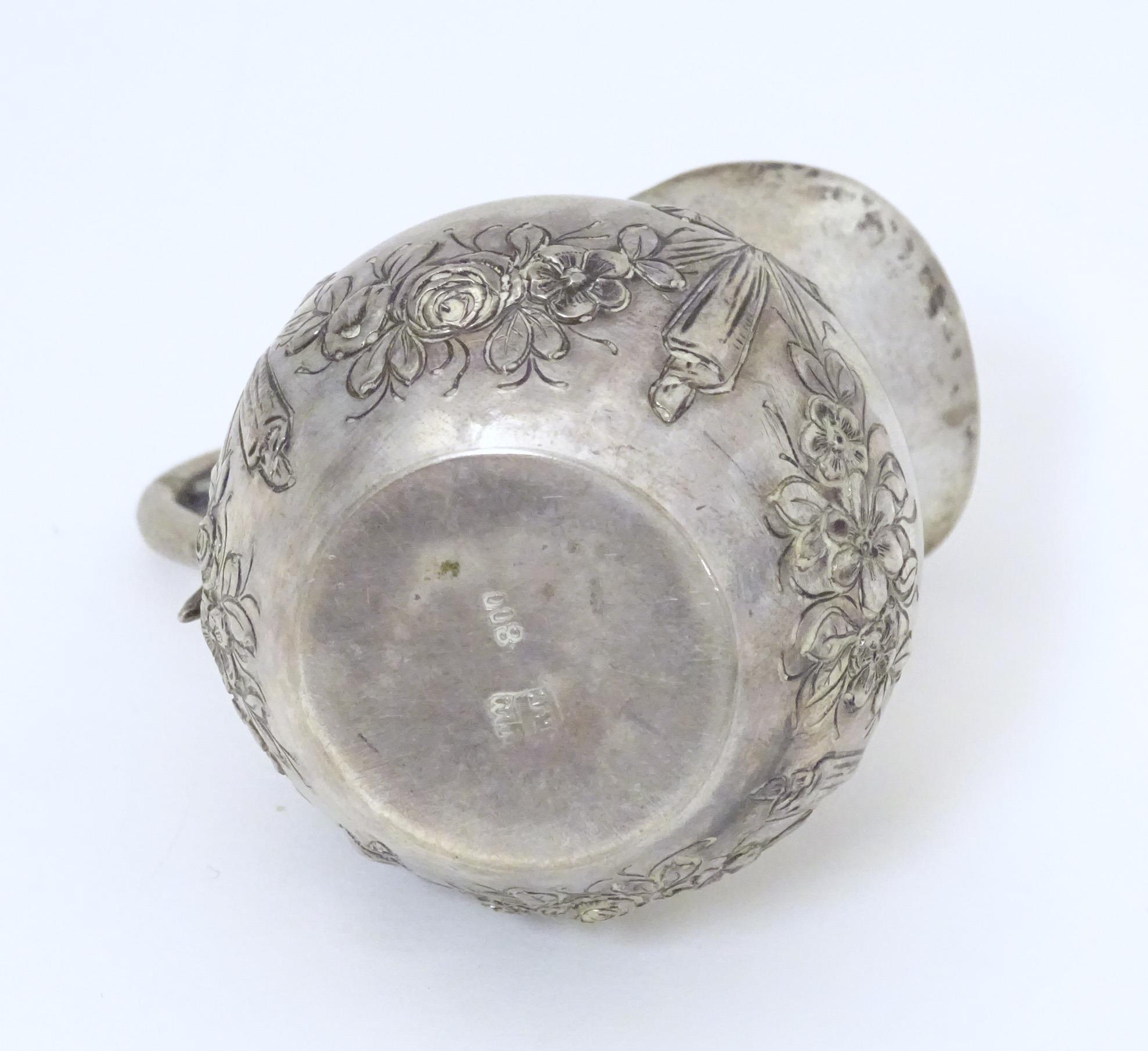 A small Continental .800 silver cream jug with ribbon and swag decoration. Marked under possibly - Image 5 of 5