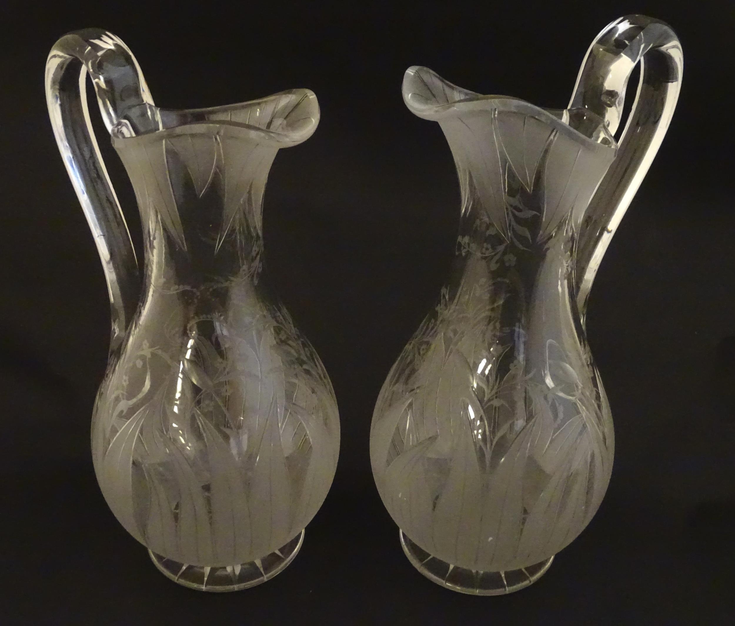 A pair of 19thC jugs with etched decoration depicting floral and foliate detail probably by