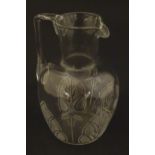 A glass water jug with foliate detail Approx 7" high Please Note - we do not make reference to the