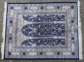 Carpet / rug: A blue ground rug with column and arch with floral and scroll detail. Approx. 66 1/