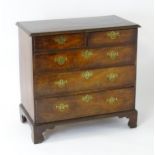 A mid 18thC mahogany chest of drawers with a moulded top above two short over three long drawers