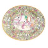 A Cantonese / Chinese famille rose dish of oval form, the centre decorated with figures, bordered by