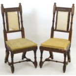 A pair of 19thC oak Gothic chairs, mounted by carved finials above incised frames with turned