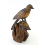 A 20thC carved wooden model of magpie / bird on a rocky outcrop. Signed with initials P. N. and