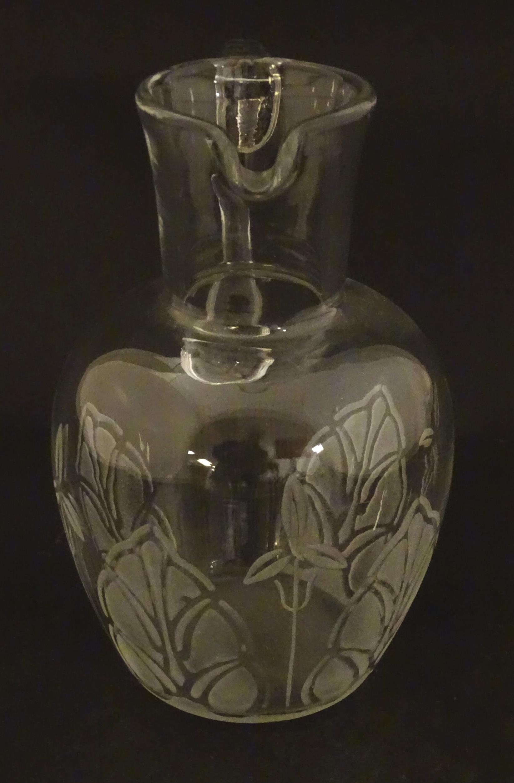 A glass water jug with foliate detail Approx 7" high Please Note - we do not make reference to the - Image 4 of 6