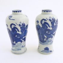 A pair of Chinese blue and white vases decorated with a Chinese dragon parade with figures in a