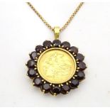 A 1914 half sovereign coin within a 9ct gold pendant mount bordered by garnets, on a 9ct gold