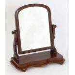 A late 19thC mahogany toilet mirror, having an arched surround and scrolled supports above a