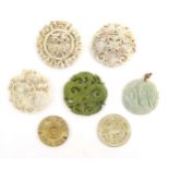 Seven assorted carved Oriental roundels / pendants, detail to include dragons, birds, stylised rams,