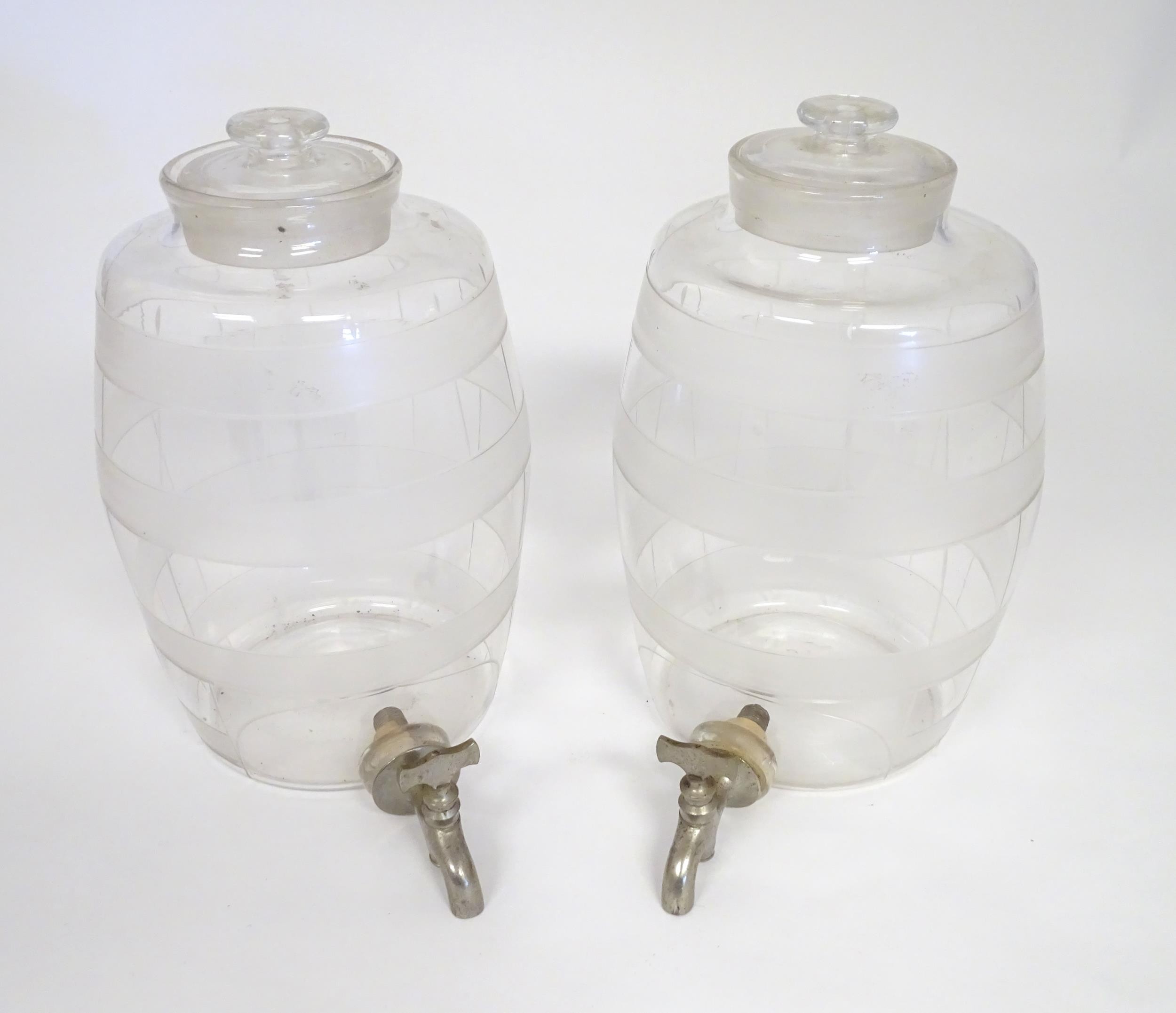 Two Victorian glass spirit / rum barrels with etched decoration and with silver plated taps.