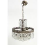 An early 20thC crystal drop bag pendant ceiling light, the chain supporting brass mounts with a