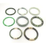 A quantity of assorted bangle bracelets, some jade hardstone examples. (8) Please Note - we do not