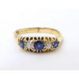 An 18ct gold ring set with diamonds, sapphire and blue stone detail. Ring size approx. N Please Note