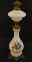 A late 19thC / early 20thC oil lamp with opaline glass body with transfer printed scene surmounted