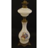 A late 19thC / early 20thC oil lamp with opaline glass body with transfer printed scene surmounted