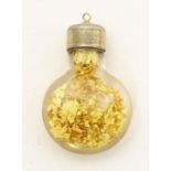 A pendant charm formed as a bottle filled with gilt flecks. Approx. 1" long Please Note - we do