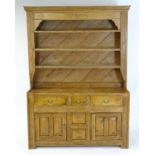 A 20thC pine dresser with a moulded cornice above floral carving flanked by reeded pilaster
