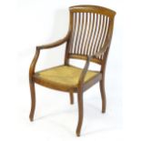 An early 20thC open armchair with a curved top rail above a raked slatted backrest and having an