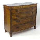 A Regency period mahogany chest of drawers with a shaped reeded front edge above four long drawers