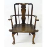 A 20thC Windsor chair with a shaped top rail above a shaped back splat and turned spindle back