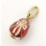 A Russian silver gilt pendant / charm of egg form with red and white enamel detail. Approx. 3/4"