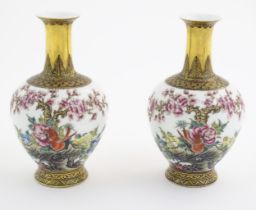 A pair of Chinese vases decorated with birds, flowers and blossom trees, with gilt detail to necks