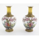 A pair of Chinese vases decorated with birds, flowers and blossom trees, with gilt detail to necks