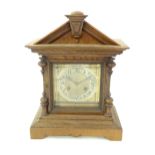 An oak cased Junghans mantel clock with silvered chapter ring having Arabic numerals and striking on