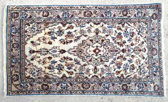 Carpet / Rug : A kashan rug with cream and beige ground and floral and foliate scroll detail.