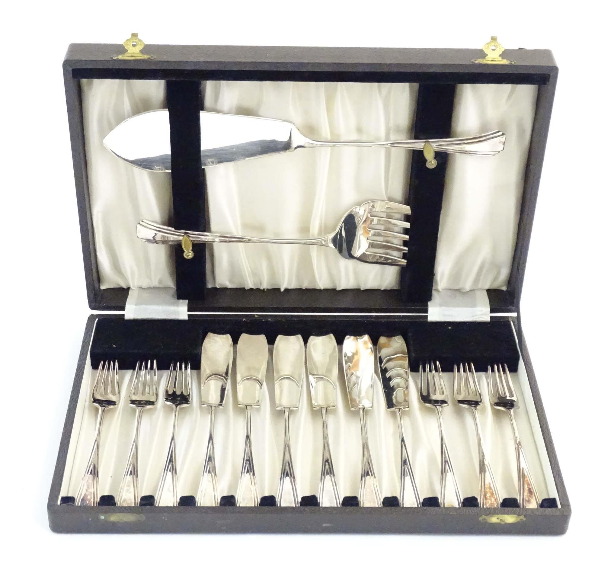 A cased silver plate six place set of fish eaters and servers with Art Deco style decoration. Please