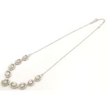 A silver necklace set with 9 facet cut Bolivarian quartz. Approx. 16" long Please Note - we do not