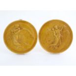 Two Dunmore pottery roundel / plaques depicting a female angel carrying children. One stamped