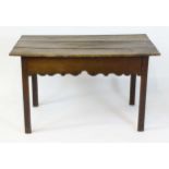 An 18thC oak centre table with a three plank top above a carved frieze and four chamfered legs.