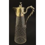 A cut glass claret jug with cut decoration and silver plate mounts, the handle formed as entwined