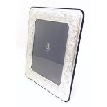 An Italian photograph frame with easel back and white metal surround with acanthus scroll