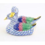 A 20thC Herend pottery model of two ducks with fishnet decoration and gilt highlights. Marked under.