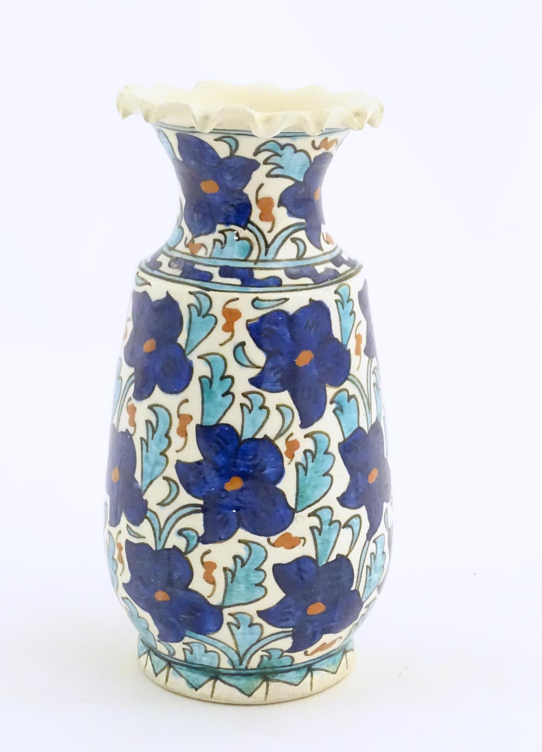 An Iznik style vase with blue, white and red floral and foliate detail. Approx. 7 3/4" high Please