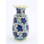 An Iznik style vase with blue, white and red floral and foliate detail. Approx. 7 3/4" high Please