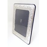 An Italian photograph frame with easel back and white metal surround with acanthus scroll