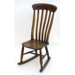 An early 19thC Windsor rocking chair with a shaped top rail and lathe back above an elm seat and two