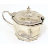 A silver mustard pot of octagonal form with blue glass liner. Hallmarked Birmingham 1933, maker