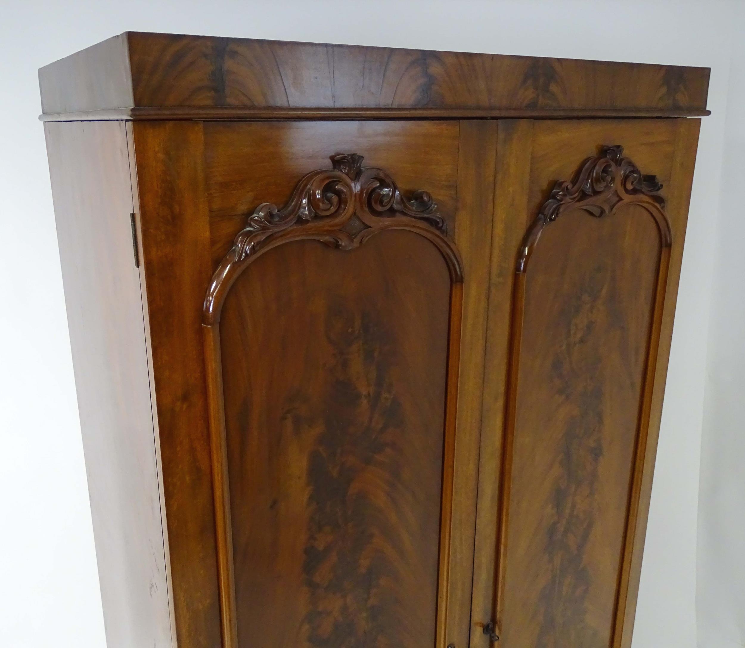 A mid 19thC mahogany double wardrobe with two panelled doors adorned with carved foliage and opening - Image 5 of 9