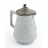 A Victorian stoneware jug with a pewter lid, the body with moulded decoration depicting birds,