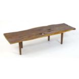 A mid century Reynolds of Ludlow yew wood coffee table raised on four tapering legs. 61" wide x