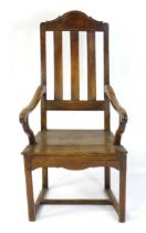 An early 18thC Scottish fruitwood and elm open armchair with a shaped top rail above a raked slatted