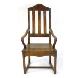 An early 18thC Scottish fruitwood and elm open armchair with a shaped top rail above a raked slatted