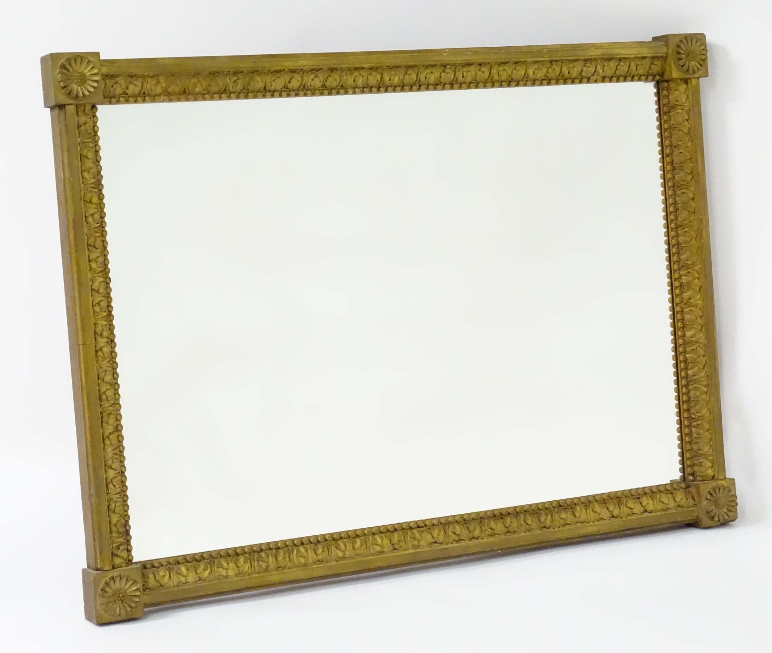 A late 18th / early 19thC mirror with a giltwood and gesso frame, having carved florets to the