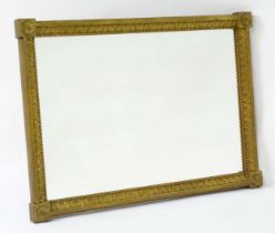 A late 18th / early 19thC mirror with a giltwood and gesso frame, having carved florets to the