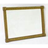 A late 18th / early 19thC mirror with a giltwood and gesso frame, having carved florets to the