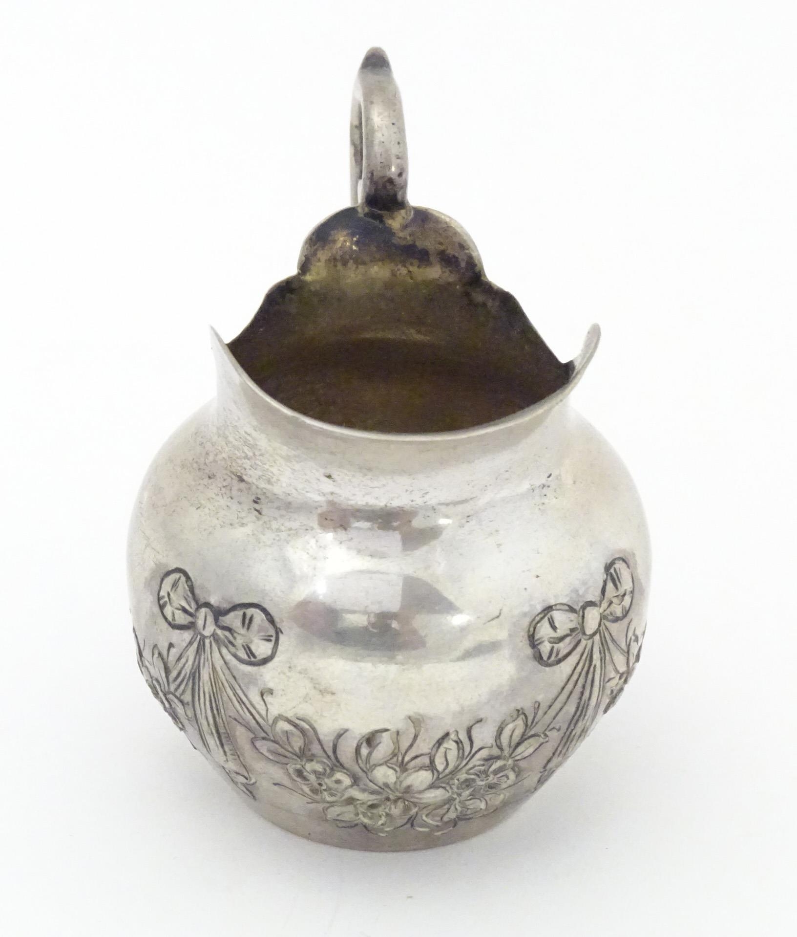 A small Continental .800 silver cream jug with ribbon and swag decoration. Marked under possibly - Image 4 of 5